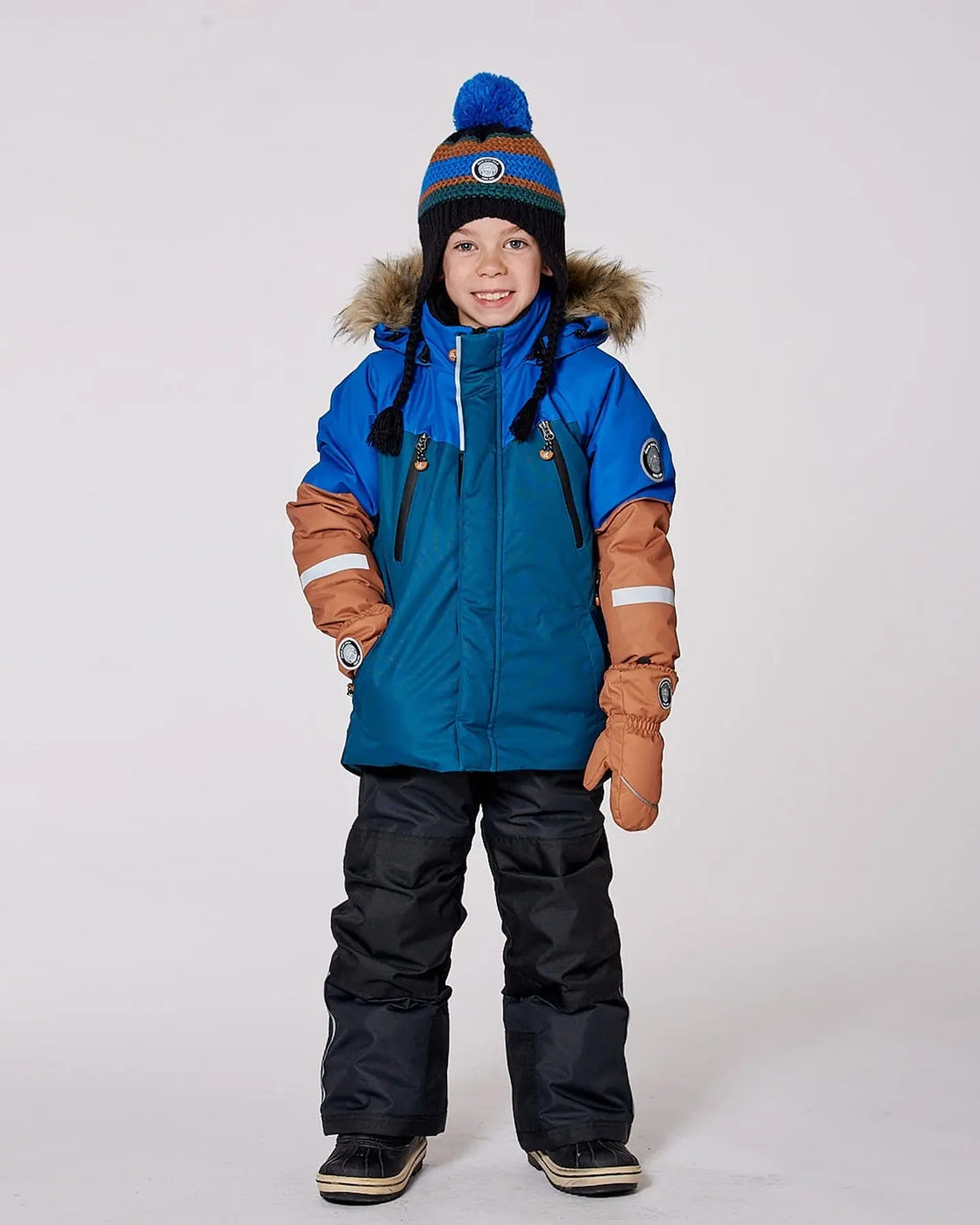 Boy wearing black and blue Deux par Deux ski suit outdoors