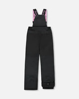 Black bib pants with Cordura knees and ankle gaiters — girls jacket and snow pants.