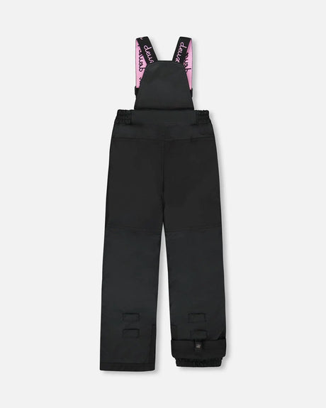 Black bib pants with Cordura knees and ankle gaiters — girls jacket and snow pants.