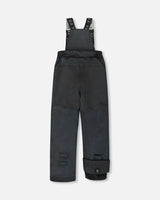 Black bib pants with Cordura knees and ankle gaiters — boys jacket and snow pants.