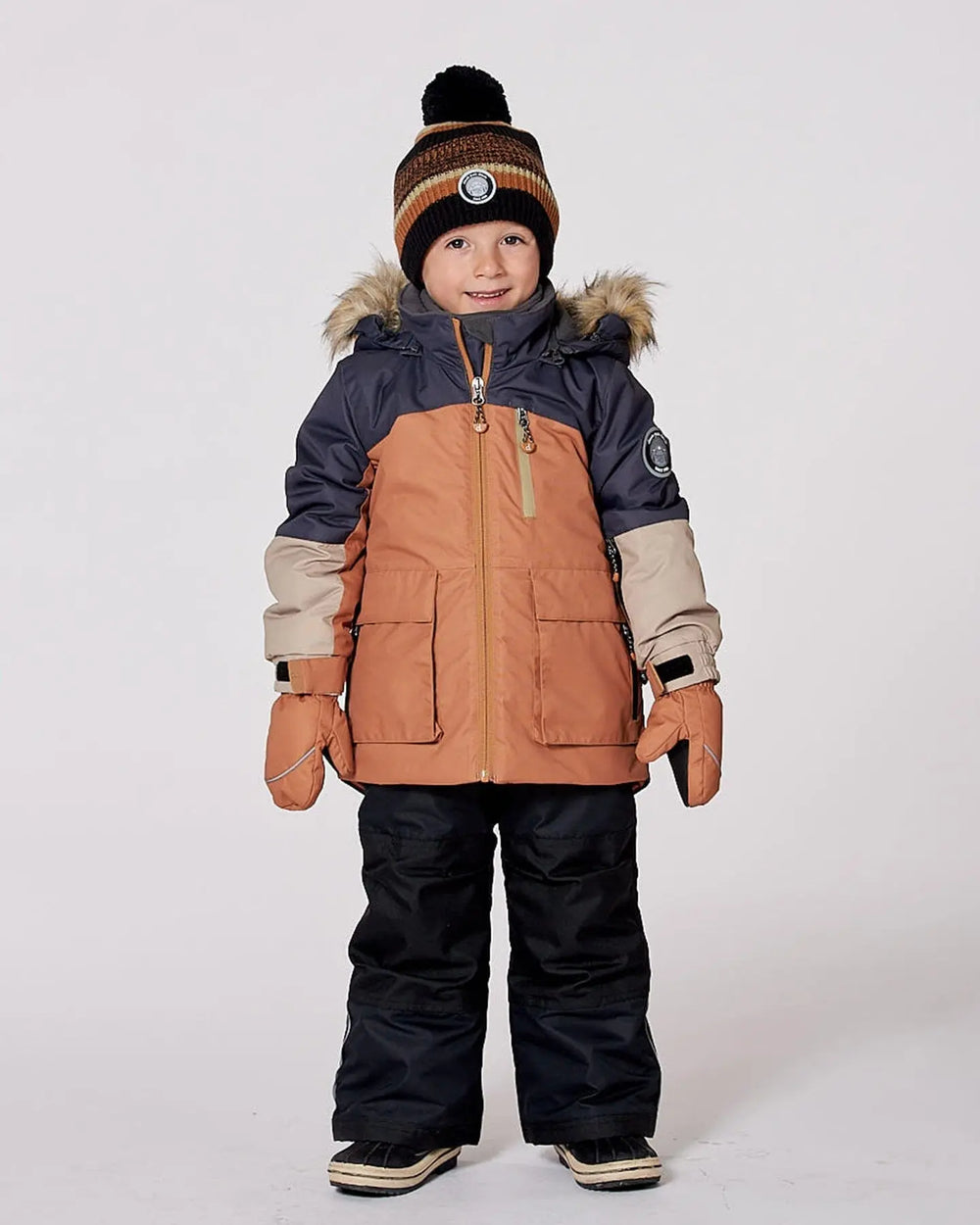 Model in colorblock jacket and snow pants, detachable hood and snow skirt.