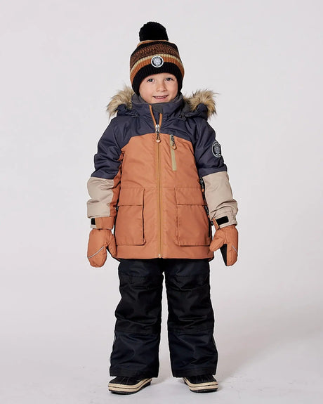 Model in colorblock jacket and snow pants, detachable hood and snow skirt.