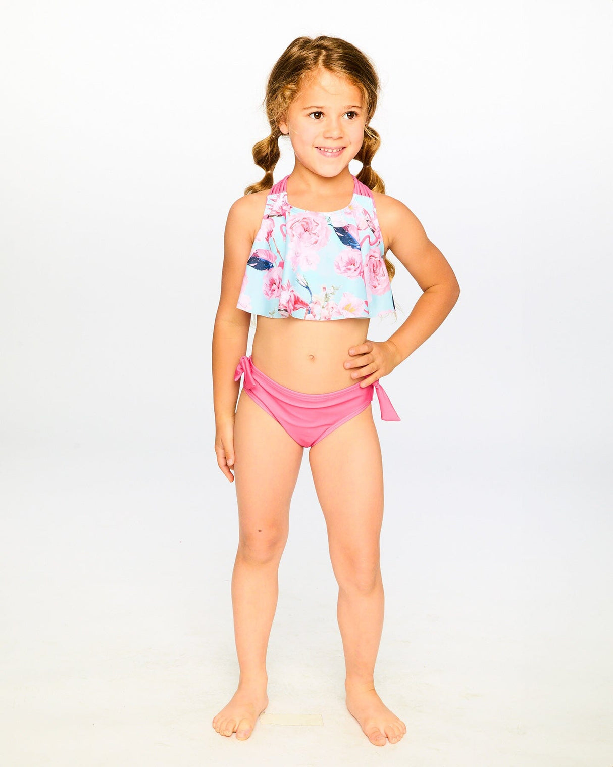 Studio front view of girl wearing blue flamingo two-piece swimsuit full body