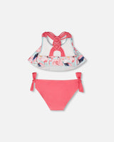 Close-up of ruffled flounce top and straps on blue flamingo print girl bikini