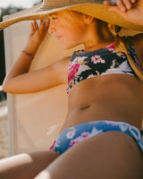 Close-up of girl lounging in Blue Rose bikini top and bottoms at the pool