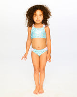 Girl wearing Deux par Deux blue seahorse two-piece swimsuit for a sunny pool or beach day.