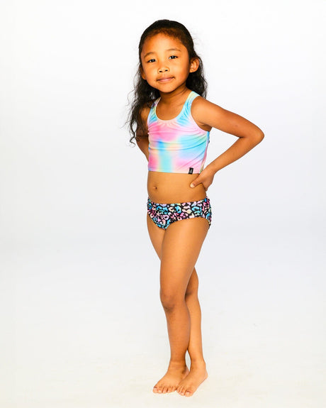 Girl wearing Deux par Deux two-piece swimsuit for a colorful summer pool and beach outfit.
