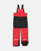 Snow pants in red with reinforced knees and adjustable suspenders