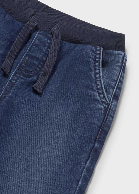 Closeup of Mayoral elastic waist jeans showing drawstring, side pocket, and denim texture.