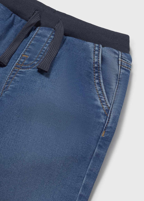 Closeup of Mayoral elastic waist baby jeans showing drawstring, side pocket, and soft denim texture.