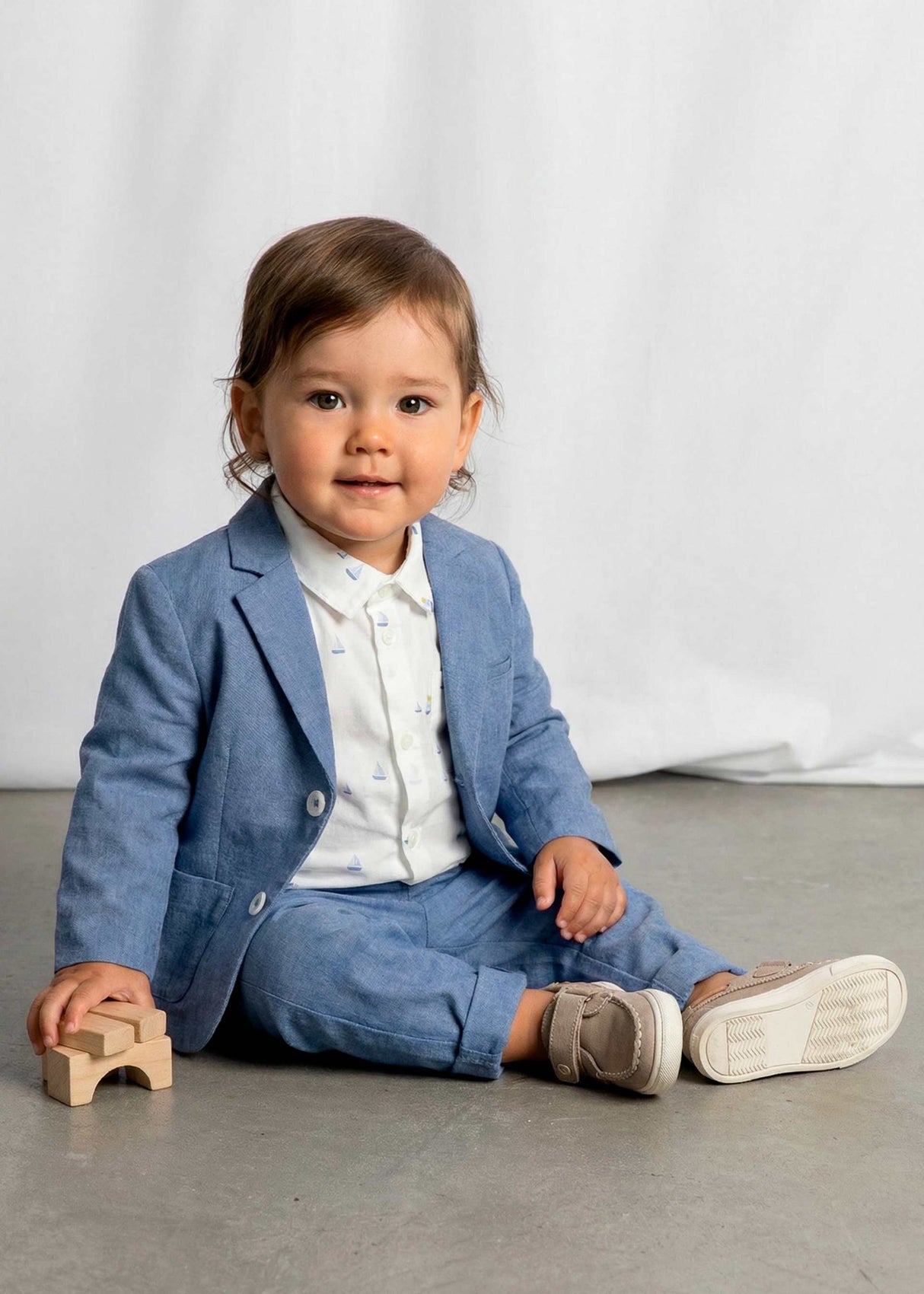 Sitting baby in Mayoral baby boy blazer styled for family photos and dressy events.