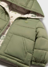 Close-up of Mayoral baby boy reversible puffer jacket showing dinosaur print lining, Olive Green side, and quilted detail.