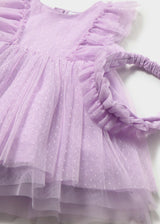 Closeup of Mayoral baby tulle dress showing Swiss dot texture, ruffle detail, and matching headband.