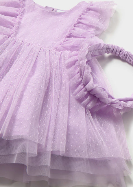 Closeup of Mayoral baby tulle dress showing Swiss dot texture, ruffle detail, and matching headband.
