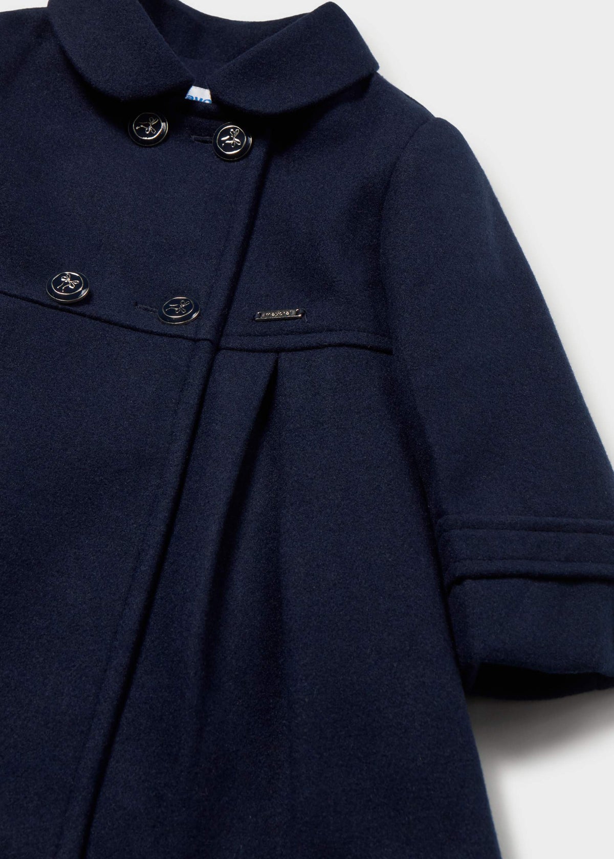 Close-up of four buttons and the round collar on the navy double-breasted coat