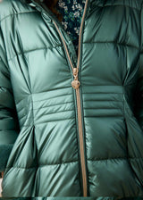 Close-up of the gold zip pull and quilted waist on the metallic green puffer