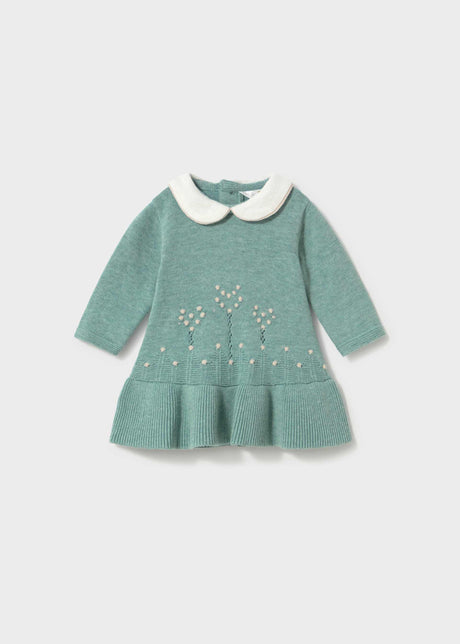 Front view of the sage green knit dress with a white Peter Pan collar and cream flower stems