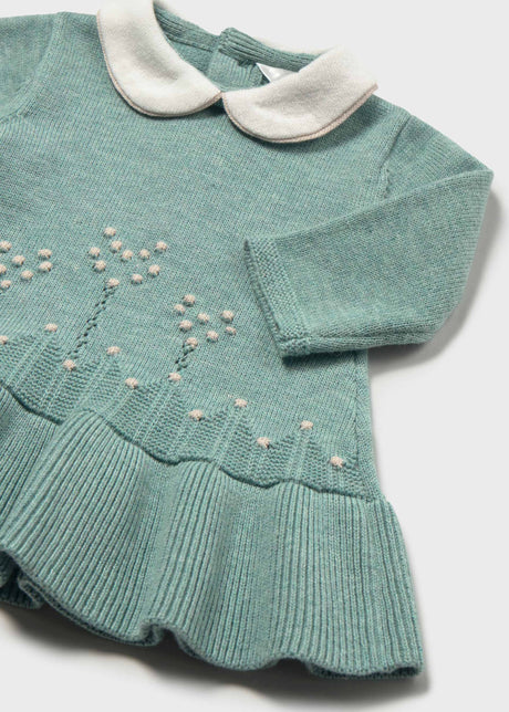 Close-up of the white collar bobble flower stems and ribbed ruffle on the sage green dress