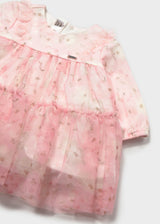 Close-up of pink floral tulle tiers and ruffle trim on the baby dress