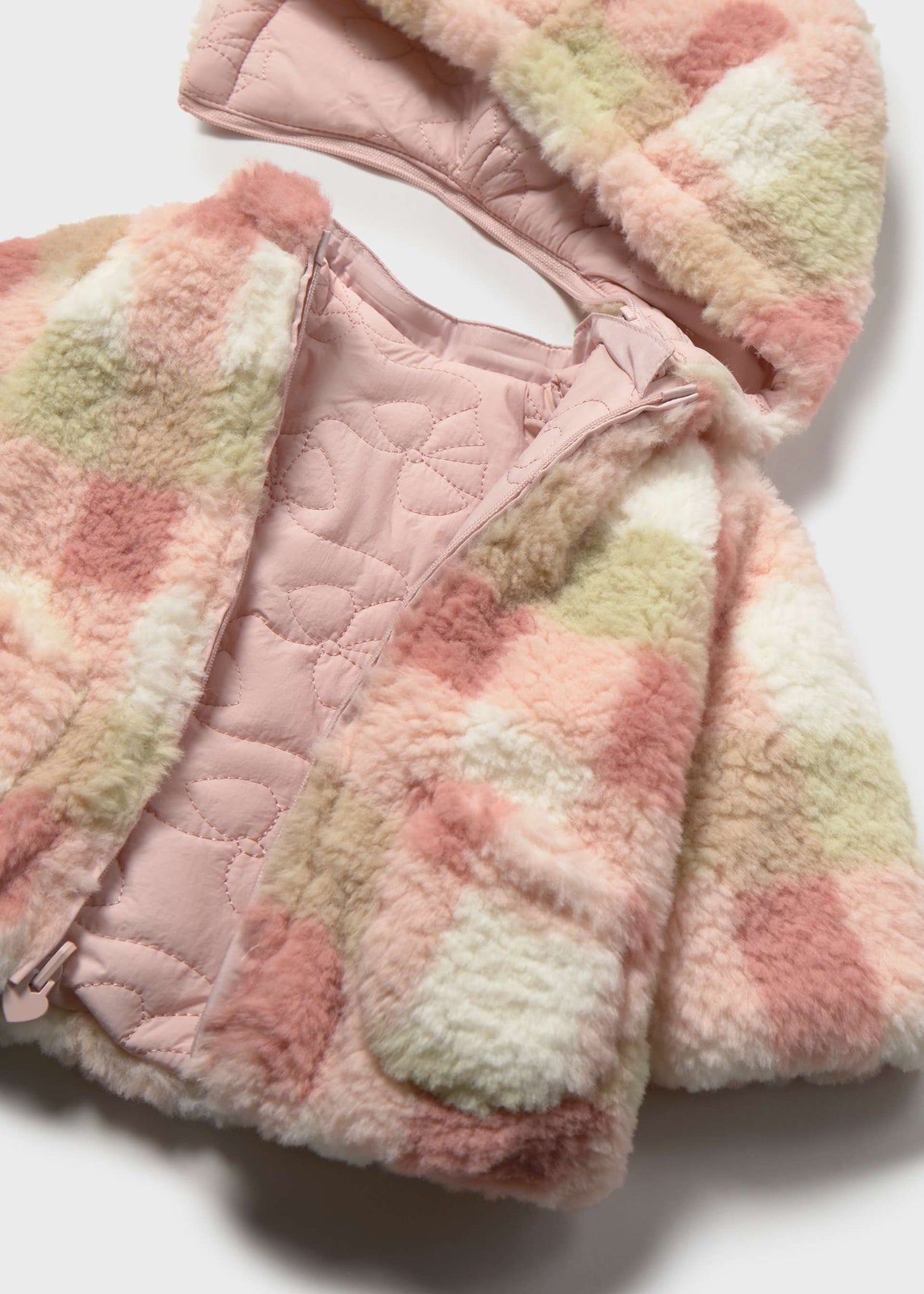 Close-up of Mayoral baby girl reversible puffer jacket showing Pink quilted fabric, plaid lining, and zipper detail.