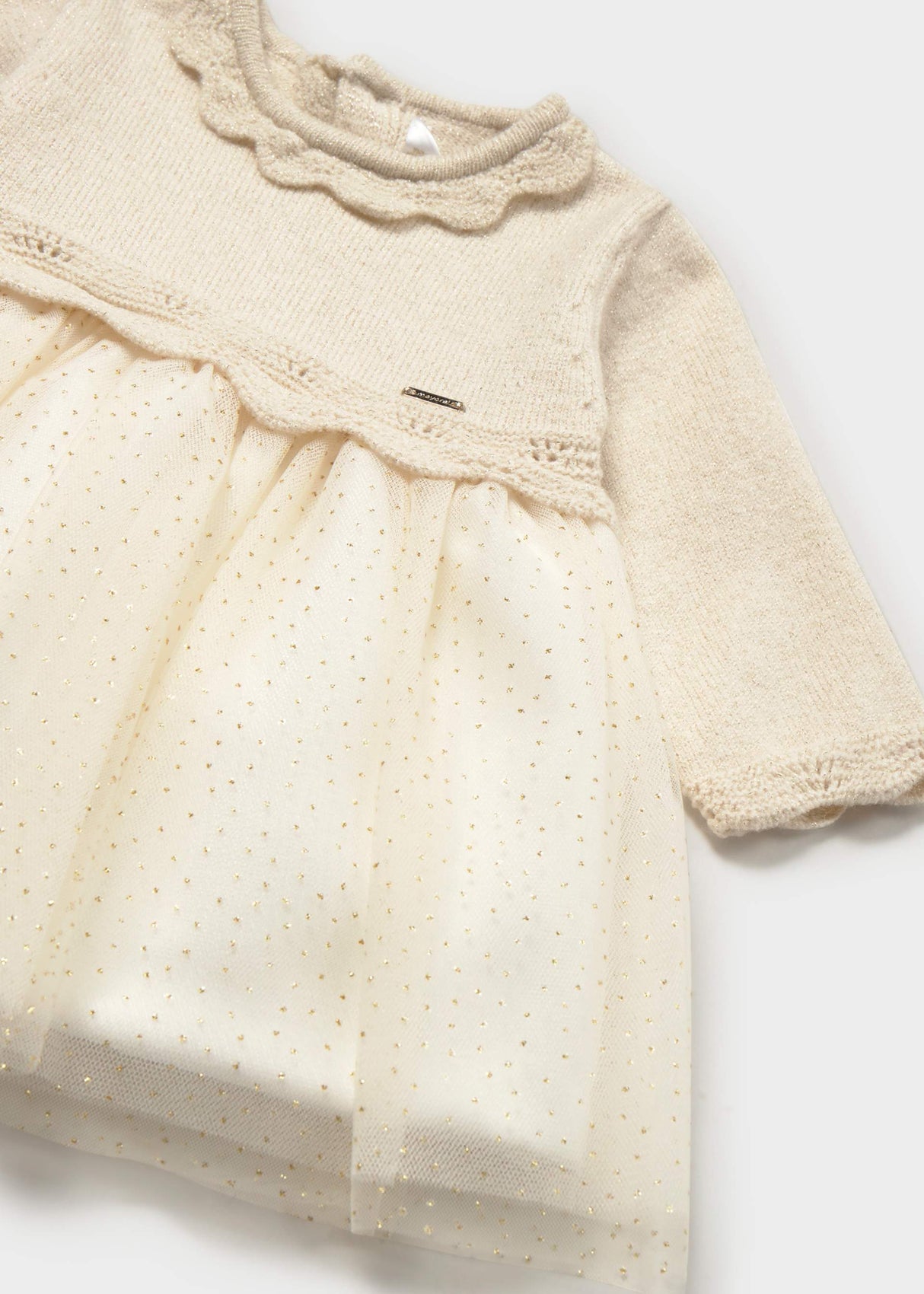 Close-up of Mayoral baby girl tulle dress showing Ivory fabric, subtle shimmer, and gathered skirt detail.