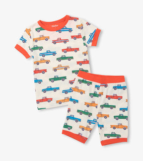 Hatley boys bamboo short pajama set in Cream/Orange with colorful trucks print and matching shorts.
